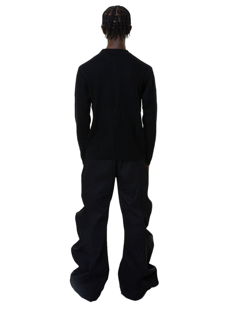 Person wearing a black denim outfit on a white background