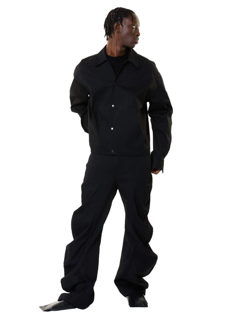Person wearing a black denim outfit on a white background