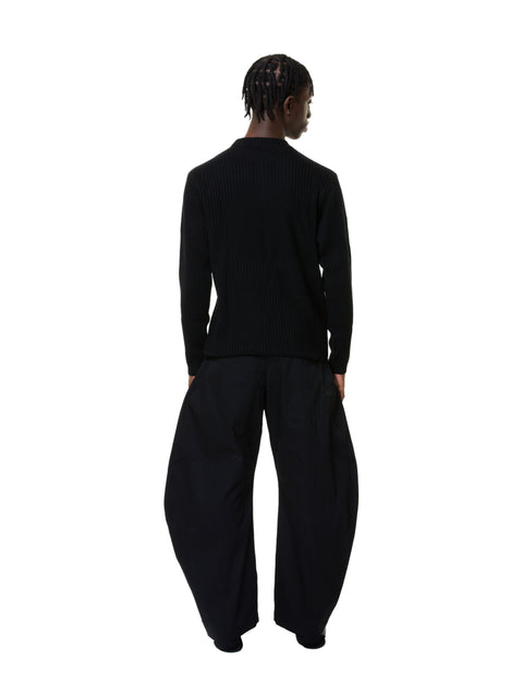 Person wearing a black outfit on a white background