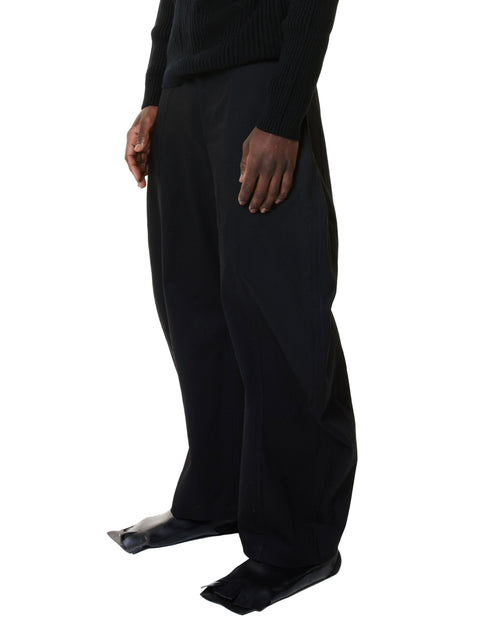 Person wearing black pants and shoes on a white background