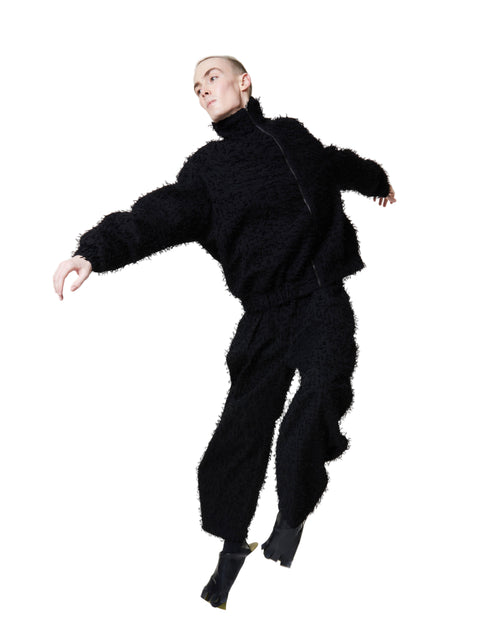 Person wearing a black outfit on a white background