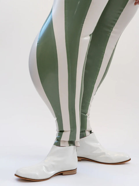 Person wearing a white jacket and green and white striped pants on a white background