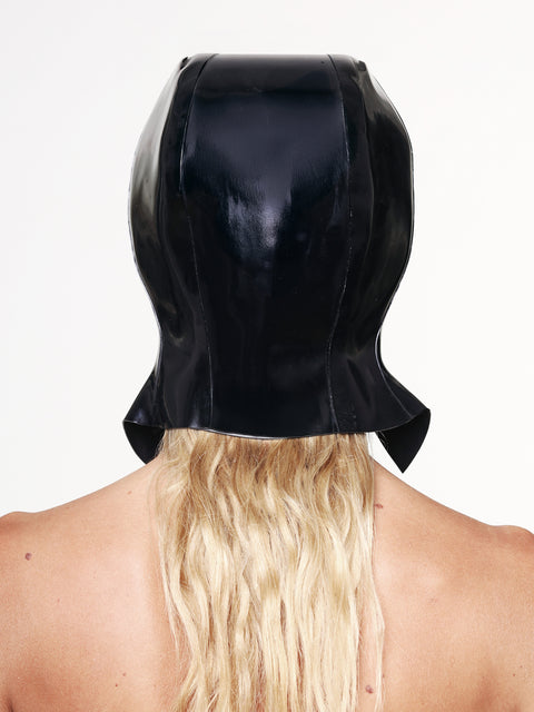 Back view of a black cap with ear flaps made of shiny material, worn over long blonde hair