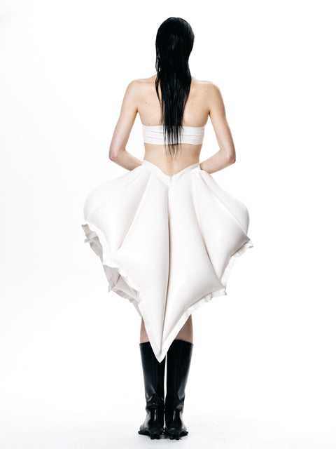 Back view of model wearing HARRI EXCLUSIVE White V-Waisted Inflatable Midi Skirt styled with black boots
