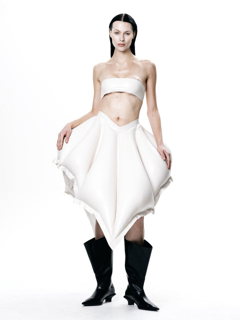 Model wearing HARRI EXCLUSIVE White V-Waisted Inflatable Midi Skirt paired with black boots and white bandeau top