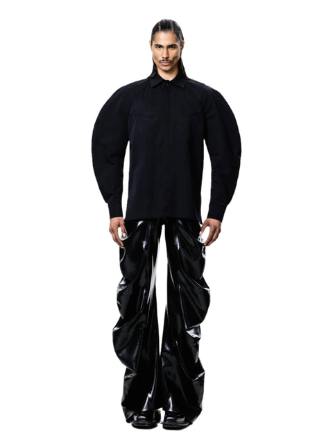 Man wearing black shirt and glossy black HARRI Trousers for men and women with a modern wide-leg design