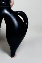 A person wearing black inflatable trousers shaped like a vase with handles at the waist with Tank top