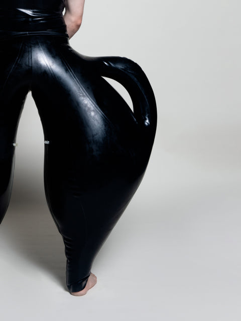 A person wearing black inflatable trousers shaped like a vase with handles at the waist with Tank top