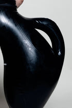 A person wearing black inflatable trousers shaped like a vase with handles at the waist with Tank top