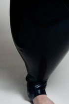 A person wearing black inflatable trousers shaped like a vase with handles at the waist with Tank top