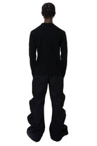 Person wearing a black denim outfit on a white background