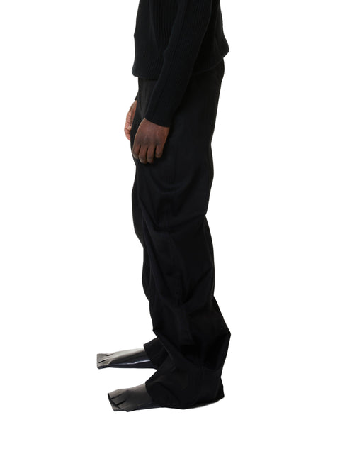 Person wearing black denim pants on a white background