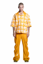 Person wearing a HARRI yellow printed Shirt with deflated trousers on a white background