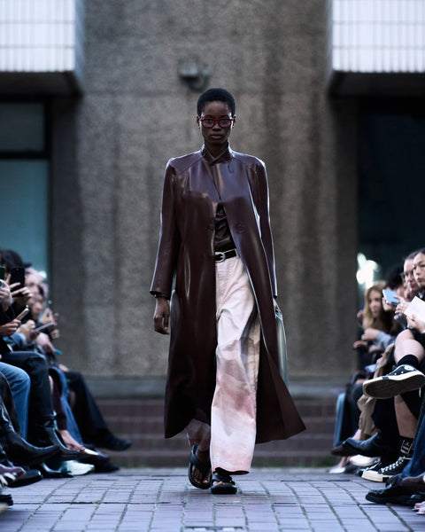 HARRI Brown shirt layered with a brown trench coat paired with printed white trousers
