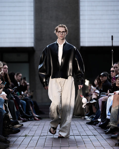 HARRI Classic white shirt layered under black bomber jacket with embroidered white trousers