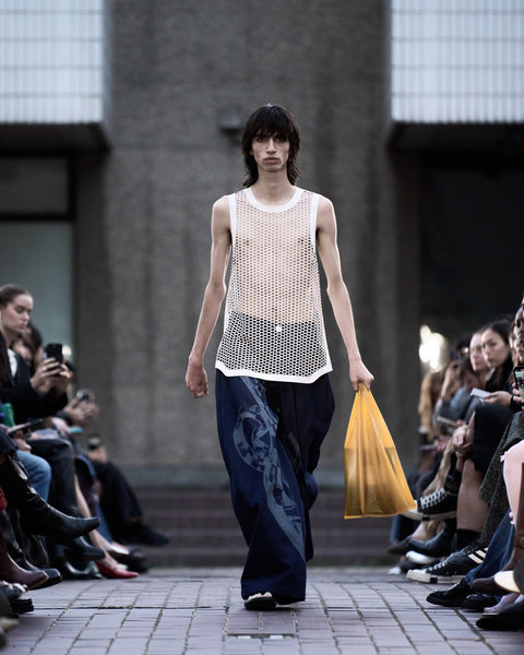 HARRI Laser cut tank top paired with printed blue jeans and a tote bag