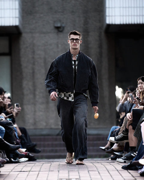 HARRI Printed shirt layered under a black denim bomber jacket and printed black jeans