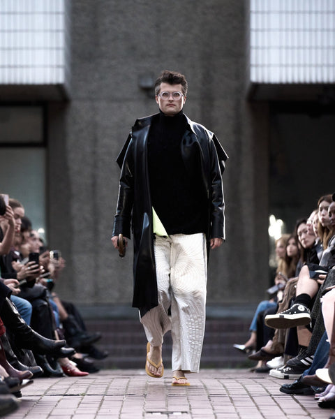 HARRI Black trench coat paired with embroidered white trousers