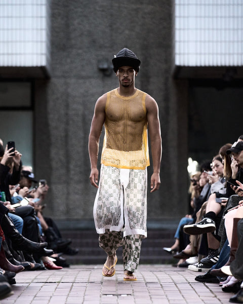 HARRI Yellow laser cut tank top paired with green and white printed trousers, layered with laser cut white trousers