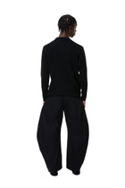 Person wearing a black outfit on a white background