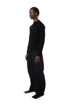 Person wearing a black outfit on a white background