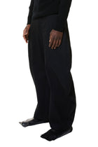 Person wearing black pants and shoes on a white background
