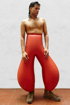 A person wearing red inflatable trousers, standing against a plain background.