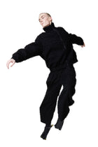 Person wearing a black outfit on a white background
