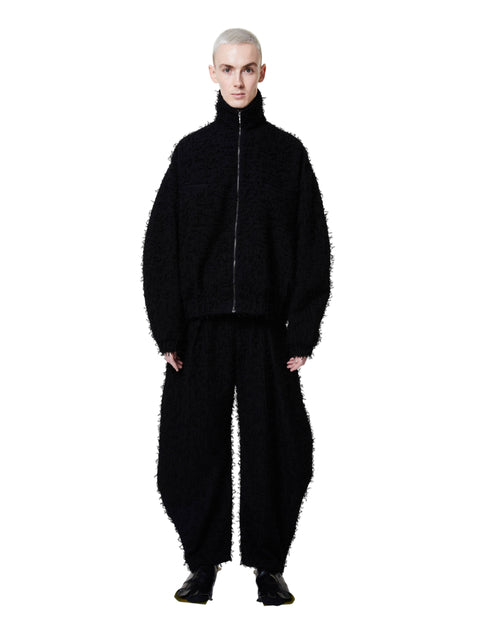 Person wearing a black textured outfit on a white background