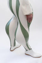 Person wearing a white jacket and green and white striped pants on a white background