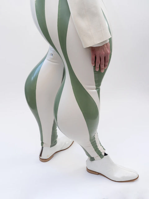 Person wearing a white jacket and green and white striped pants on a white background