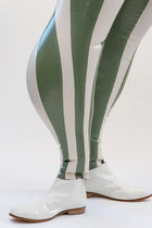 Person wearing a white jacket and green and white striped pants on a white background