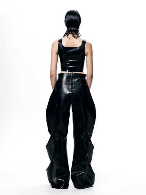 Back view of model wearing HARRI black cropped fitted tank top with shiny black wide-leg pants