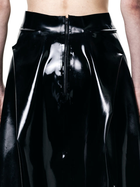 HARRI black pleated skirt with shiny finish and front zipper closure on model