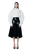 Black Pleated Skirt by HARRI worn with white blouse and black heels on model
