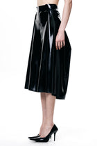 HARRI black pleated skirt with glossy finish worn with black high heels