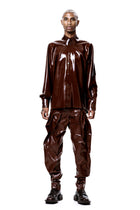 Brown Alien Legs Inflatable Trousers by HARRI EXCLUSIVE worn with matching glossy brown shirt and black boots