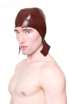 HARRI brown cap with ear flaps worn by shirtless male model in studio