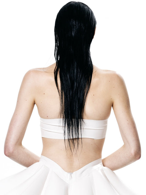 Back view of a woman wearing a white HARRI Tube Top with wet black hair and white skirt