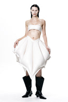 Model wearing HARRI EXCLUSIVE White V-Waisted Inflatable Midi Skirt paired with black boots and white bandeau top